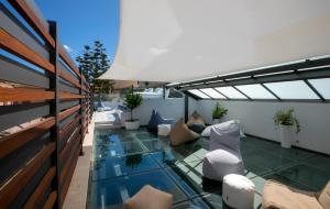 un balcone con pavimento in vetro e mobili di Azzoli Trapani - Apartments&Skypool - Adults Only a Trapani