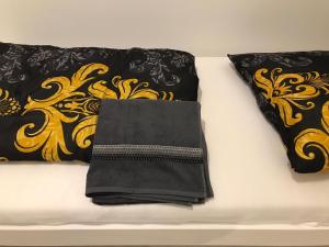 two black and gold pillows on a white couch at Roter Sandstein Zink in Mainz