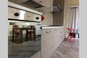 una cocina con una mesa con sillas rojas. en CASA CANTONIERA-GUEST HOUSE : COSTRUITE IL VIAGGIO, en Pompeya
