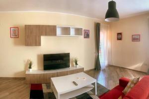 sala de estar con sofá rojo y TV en CASA CANTONIERA-GUEST HOUSE : COSTRUITE IL VIAGGIO, en Pompeya