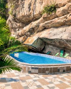 a large swimming pool next to a rock wall at Trang An Memory Homestay in Ninh Binh