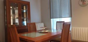 ein Esszimmer mit einem Holztisch und Stühlen in der Unterkunft PISO MONTERO RÍOS 18 in Cangas + 2 Fotos