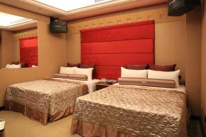 a hotel room with two beds and a red headboard at In-stone Motel in Taipei