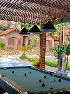 uma mesa de bilhar em frente a uma piscina em Trang An Memory Homestay em Ninh Binh