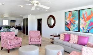 uma sala de estar com um sofá, cadeiras e uma mesa em Coral Beach Club Villas & Marina em Dawn Beach