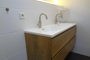 a bathroom with a white sink and a mirror at Charmante rustikale Jägersuite mit el Kamin H2O Therme Oberhof in Oberhof