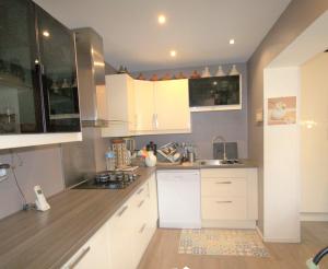 a kitchen with white cabinets and a sink at Jolie chambre Nenuphar dans belle maison in Vaulx-en-Velin