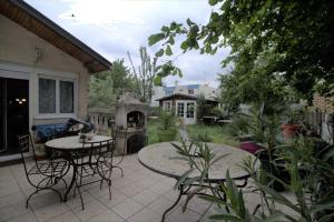 un patio con mesa, sillas y chimenea en Jolie chambre Nenuphar dans belle maison, en Vaulx-en-Velin