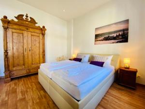 - une chambre avec un grand lit et une armoire en bois dans l'établissement Villa Anna - Johann Strauss, à Heringsdorf