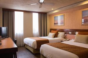 墨西哥城Hotel Marlowe Centro Histórico的有两张床和一张书桌的酒店房间 更多37张照片