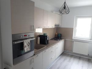 a kitchen with white cabinets and a stove top oven at Angel Residence in Sibiu