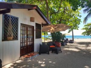 uma casa na praia com cadeiras e um guarda-sol em Macao Beach em Sámara