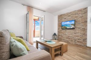 a living room with a couch and a brick wall at Apartments Vesna Vodice in Vodice