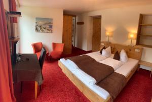 Habitación de hotel con cama grande y TV en Berghotel-Gasthof Gstrein, en Vent