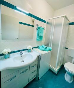 a bathroom with a sink and a shower and a toilet at La Risacca Suite in Patti