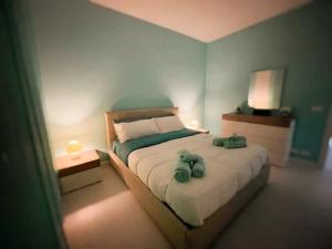ein Schlafzimmer mit einem Bett, auf dem zwei Stofftiere liegen in der Unterkunft La Risacca Suite in Patti