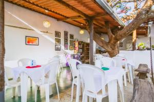 a restaurant with white tables and white chairs at Pousada Aquarela Pirenopolis in Pirenópolis