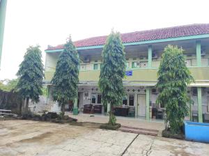 un gruppo di alberi di fronte a un edificio di OYO 90333 Wisma Tenang Jaya Syariah a Majalengka