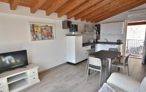 a kitchen and living room with a dining room table and a television at Blue Apartment in Marciaga di Costermano in Costermano sul Garda +7 photos