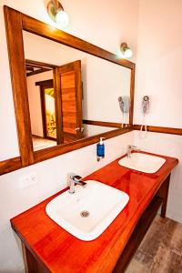 a bathroom with a sink and a mirror at Sisakuna Lodge in Mindo