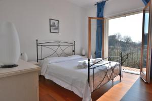 a bedroom with a bed and a large window at Orange Apartment In Marciaga di Costermano in Costermano