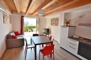 kuchnia i salon ze stołem i krzesłami w obiekcie Red Apartment in Marciaga di Costermano w mieście Costermano