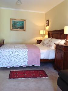 a bedroom with two beds and two lamps and a rug at The Cook Cottage in Canberra