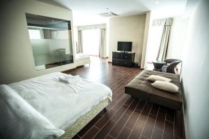 a bedroom with a bed and a couch and a mirror at Putatan Platinum Hotel in Kota Kinabalu