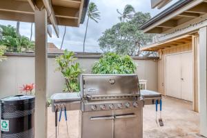 una barbacoa en un patio trasero con un cubo de basura en Maui Sands 2A, en Kahana