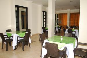 un comedor con mesas verdes y sillas en KALINA HOTEL, en Girardot