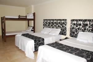 Habitación con 2 camas y sábanas blancas. en KALINA HOTEL, en Girardot