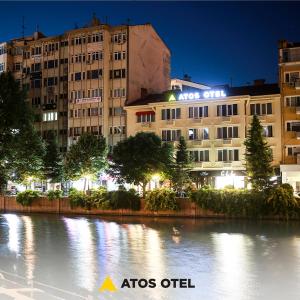 un bâtiment à côté d'une rivière la nuit dans l'établissement Atos Otel, à Eskişehir