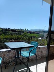 una mesa y sillas en un balcón con vistas en Taza Organic Garden with view park and restaurant, en Taza