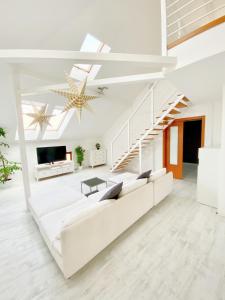 un soggiorno con divano bianco e scala di Loft with Rooftop and Garage a Budapest