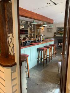 a kitchen with a bar with stools in it at The Dartmoor Inn at Lydford in Lydford