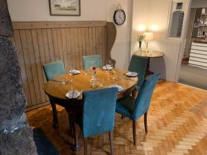 a dining room with a table and chairs and a clock at The Dartmoor Inn at Lydford in Lydford