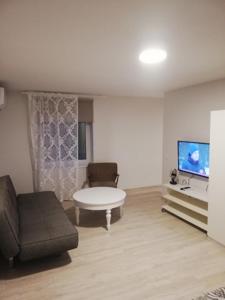 a living room with a couch and a flat screen tv at Vėjo 16 in Biržai
