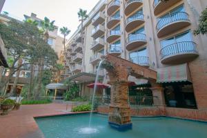 une fontaine devant un bâtiment dans l'établissement Hotel Lucerna Tijuana, à Tijuana