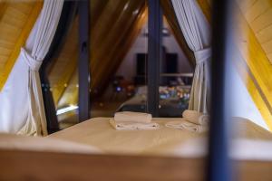 two towels sitting on top of a bed with a window at Masarotto Luxury Chalet #1 in Belgrade