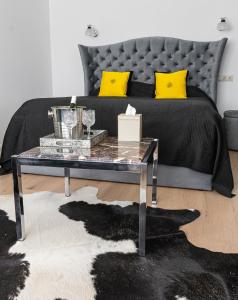 uma sala de estar com uma cama com almofadas amarelas em Central Park studio em Gulbene