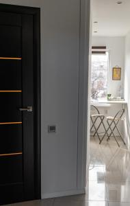 a door leading into a room with a desk and a kitchen at Central Park studio in Gulbene