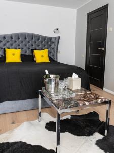 Un dormitorio con una cama con almohadas amarillas y una mesa. en Central Park studio, en Gulbene