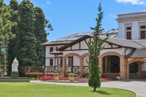 a house with a statue in front of it at Vila Dom Bosco in Campos do Jordão