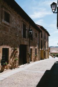 uma rua vazia ao lado de um edifício de pedra em Hotel Rural El Zaguán em Lerma