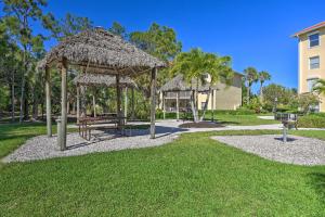 那不勒斯Quiet Lely Resort Condo with Pool - 2 Mi to Golf!的一个带野餐桌和稻草伞的公园