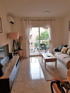 a living room with a couch and a table at Lovely 2 bedroom apartment close to Denia Castle. in Denia