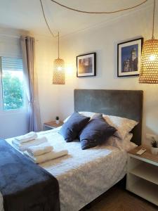 1 dormitorio con 1 cama grande con almohadas azules en Lovely 2 bedroom apartment close to Denia Castle., en Denia