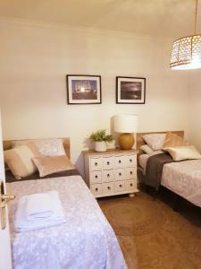 1 dormitorio con 2 camas, lámpara y cómoda en Lovely 2 bedroom apartment close to Denia Castle., en Denia