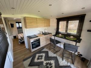 a kitchen in a tiny house with a table and chairs at Le Vert Logis in Lasne