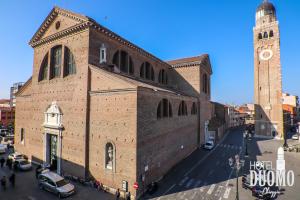 a large brick building with a clock tower on a street at Duomo Boutique Hotel in Chioggia